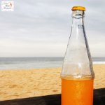 Bottle of orange juice on the beach